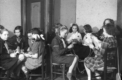 837469 Afbeelding van een aantal meisjes tijdens het handwerken in een gebouw van de Nederlands Hervormde Stadszending ...
